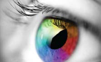 A black and white photo of an eye with the iris showing all the colors of the rainbow