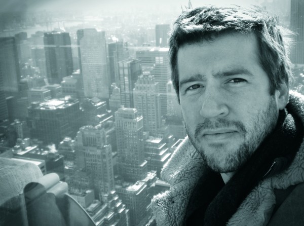 Middle-age man looking at camera with skyscrapers and other buildings in the distant background