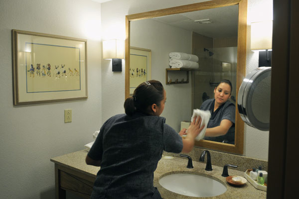 Luz Torres, a housekeeper at the Eldorado Hotel in Santa Fe, New Mexico, cleans one of the hotel’s rooms in December 2011. Torres is paid more than Santa Fe’s minimum wage.