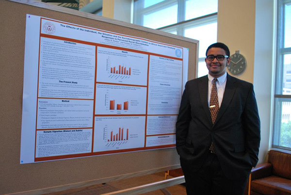 student in front of presentation poster