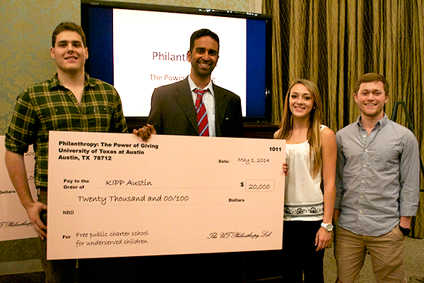 Student advocates for Caring for Cambodia present the organization's founder and CEO, Jamie Amelios, with a check.