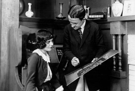 Black and white photograph of Anita Loos and John Emerson reviewing an intertitle in 1919, the year they married.