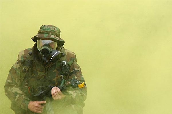 U.S. soldier practices donning his gas mask during a field exercise.