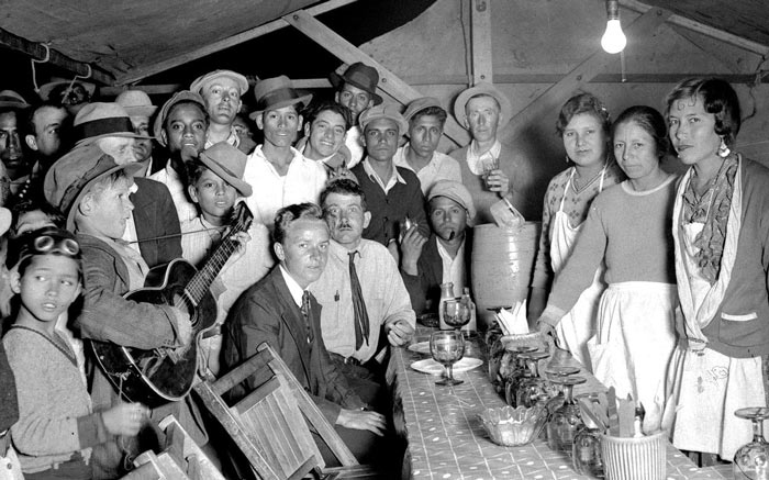 An old photo of a group of people standing around a table