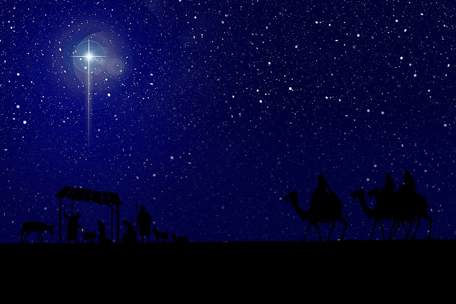 blue sky filled with stars and one bright northern star with nativity scene silhouette beneath