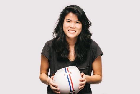 Portrait of Gloria Hwang holding a Thousand stripped helmet.