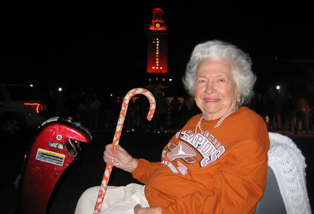 Liz Carpenter in burnt orange champions shirt with the Tower lit orange in background.
