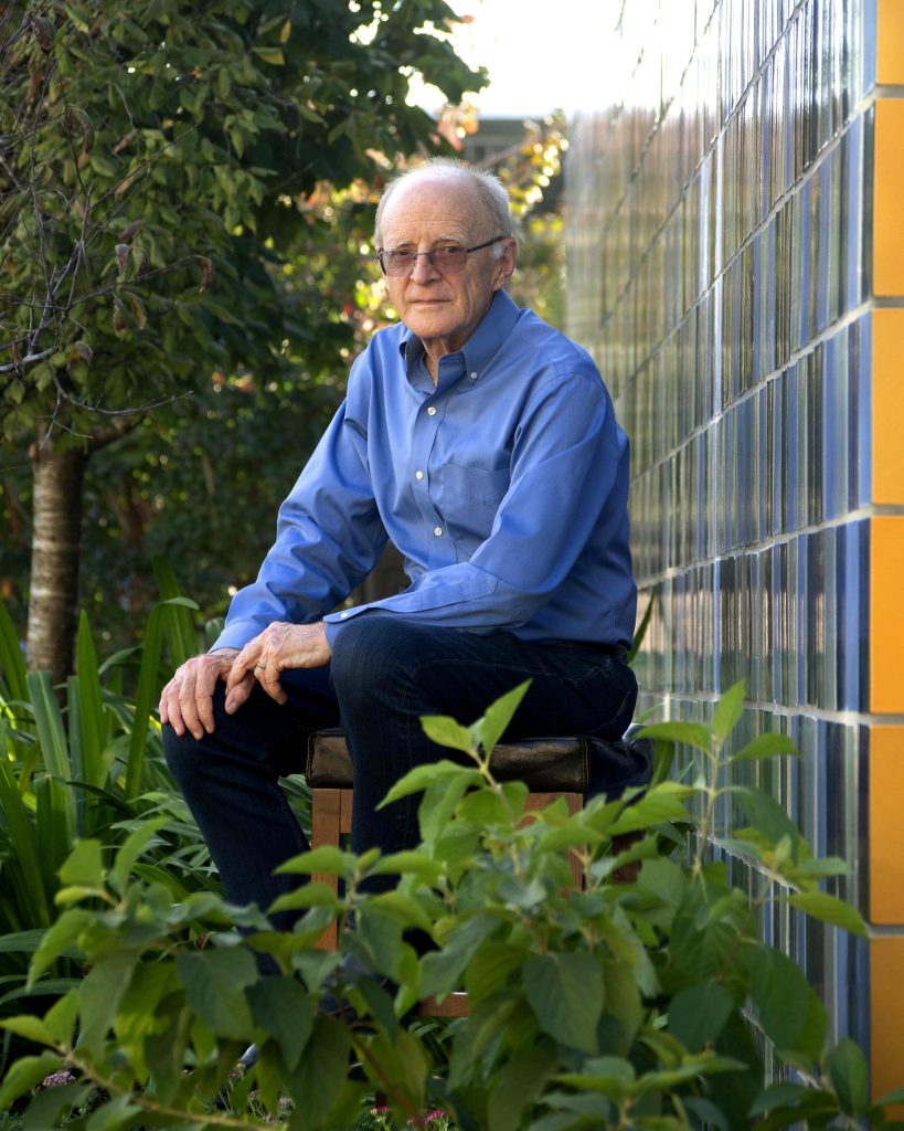 Jamie Pennebaker seated outside surrounded by greenery. 