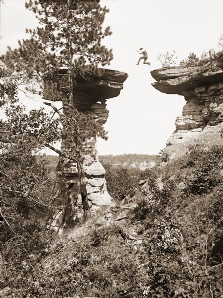 Ashley Bennett, son of photographer H.H. Bennett, jumping to Stand Rock, caught in midair by the instantaneous shutter. Modern print from original stereograph negative half, 1886.